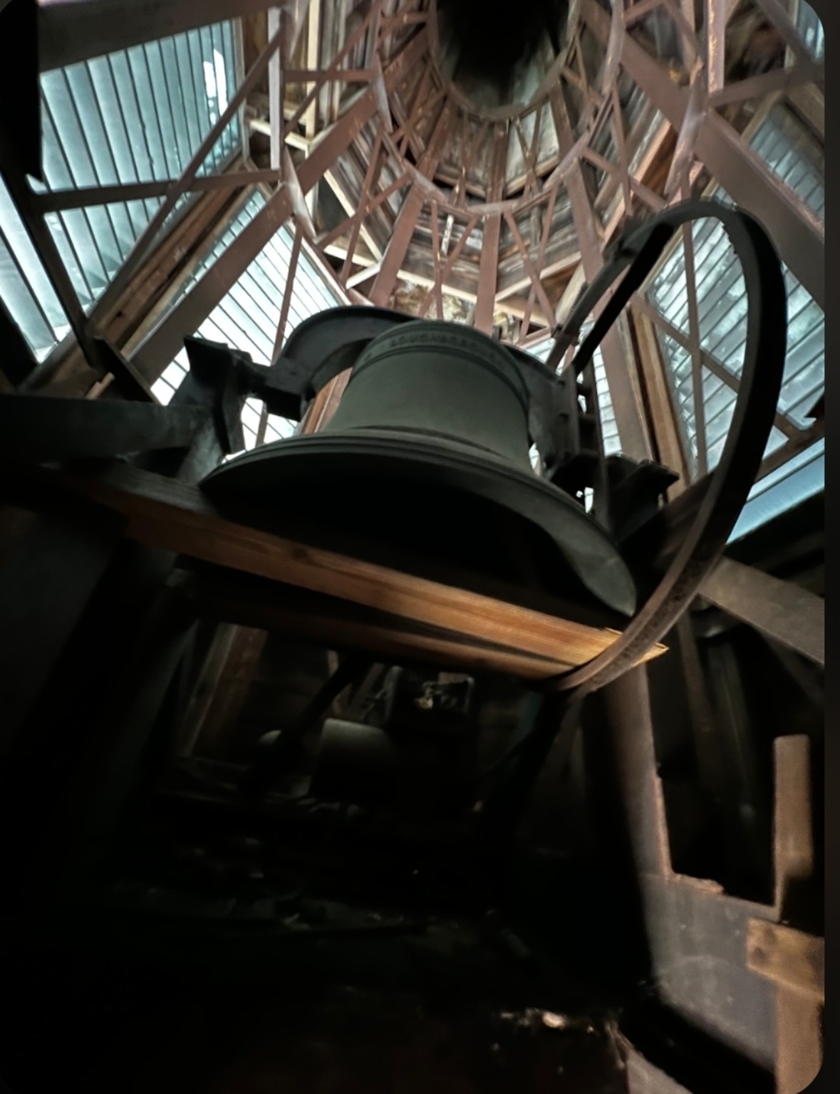 Church bell, wheel, and timber framing inside a steeple